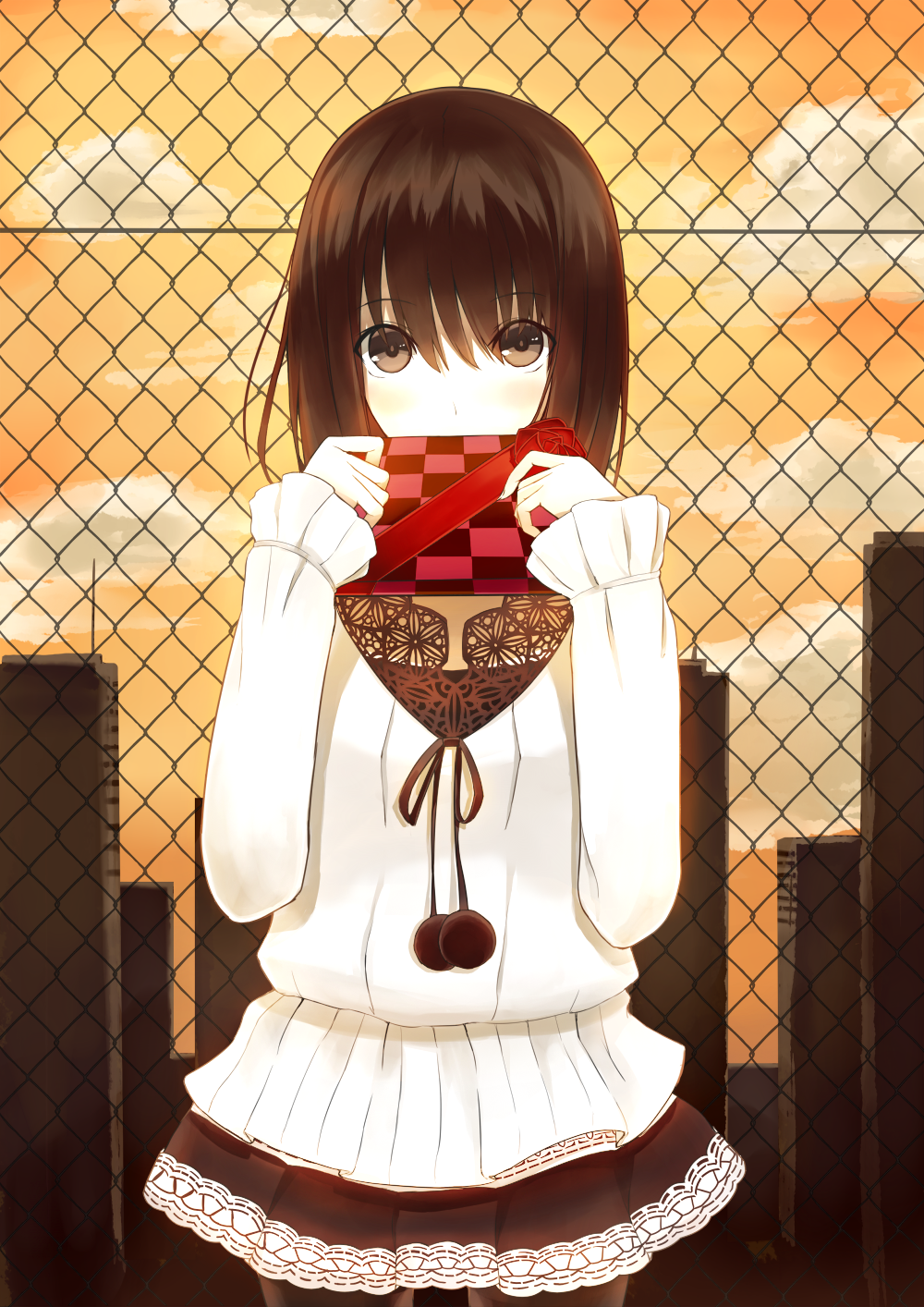 1girl blush brown_eyes brown_hair building chain-link_fence checkered covering_mouth gift highres kauto lace-trimmed_skirt original pantyhose pullover skirt solo sunset valentine