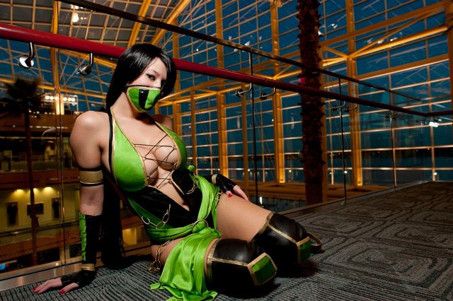 1girl arm_support asian breasts center_opening cosplay female half_mask indoors jade_(mortal_kombat) large_breasts looking_at_viewer lying mortal_kombat no_bra on_floor on_side photo revealing_clothes solo tagme
