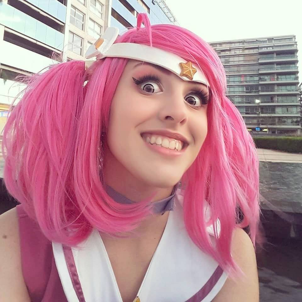 city cosplay feli_dragoon hair_ornament league_of_legends looking_at_viewer luxanna_crownguard open_mouth outdoor photo pink_hair star teeth twintails wig