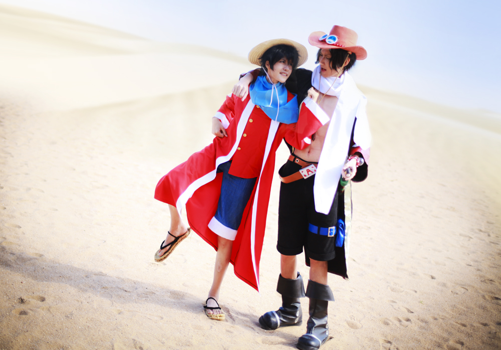 alabasta belt boots brothers cloak cosplay denim denim_shorts han-kouga hat monkey_d_luffy one_piece open_clothes open_shirt photo portgas_d_ace sand sandals scarf shirt shorts siblings stampede_string straw_hat thigh_strap vest