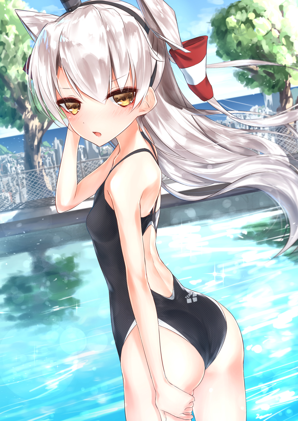 1girl amatsukaze_(kantai_collection) arena_(company) ass black_swimsuit chain-link_fence chestnut_mouth competition_swimsuit cowboy_shot dutch_angle fence from_behind hair_tubes hat highres kanju kantai_collection long_hair looking_at_viewer one-piece_swimsuit pool silver_hair solo swimsuit tree two_side_up windsock