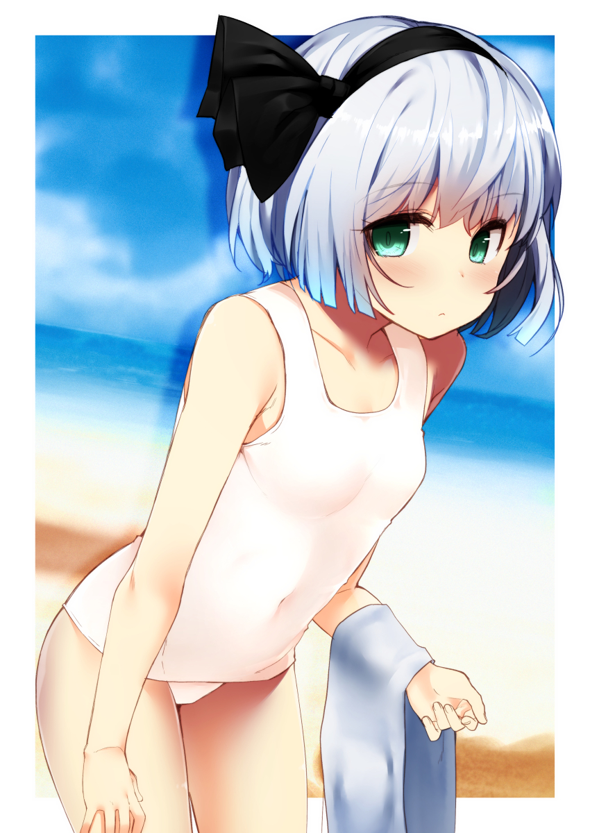 1girl bangs bare_arms bare_shoulders beach black_hairband black_ribbon blue_sky blush border breasts collarbone commentary_request covered_navel cowboy_shot day eyebrows_visible_through_hair green_eyes hair_ribbon hairband highres holding holding_towel konpaku_youmu leaning_forward looking_at_viewer nigo_(aozoragarou) outdoors outside_border portrait ribbon sand shadow short_hair silver_hair sky small_breasts solo standing swimsuit thighs touhou towel water white_border white_swimsuit