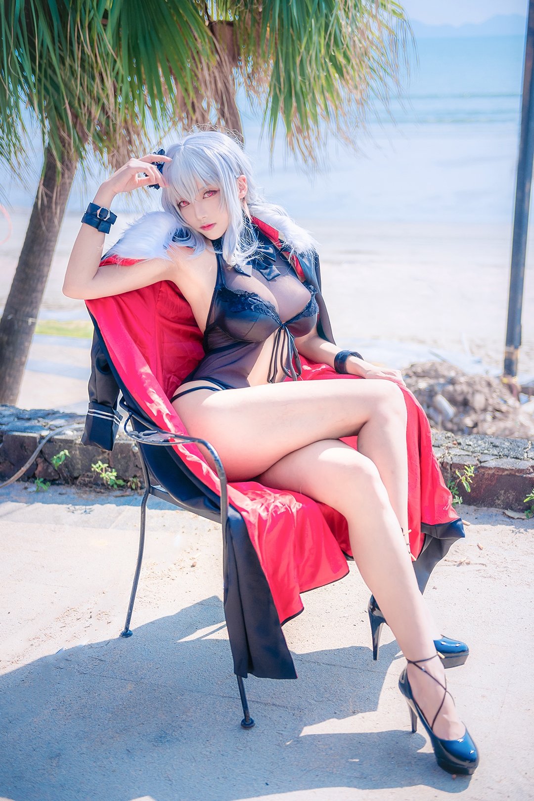 1girl arm_up armpits asian azur_lane bangs bare_legs black_coat black_swimsuit blue_footwear blurry breasts buckle casual_one-piece_swimsuit chair cleavage closed_mouth coat coat_removed cosplay day depth_of_field expressionless full_body fur-trimmed_coat fur_trim graf_zeppelin_(azur_lane) graf_zeppelin_(azur_lane)_(cosplay) hair_ornament head_tilt high_heels highres large_breasts legs_crossed long_hair looking_at_viewer ocean on_chair one-piece_swimsuit palm_tree photo pink_eyes pink_lips shadow silver_hair sitting solo sunlight swimsuit tree water wrist_cuffs