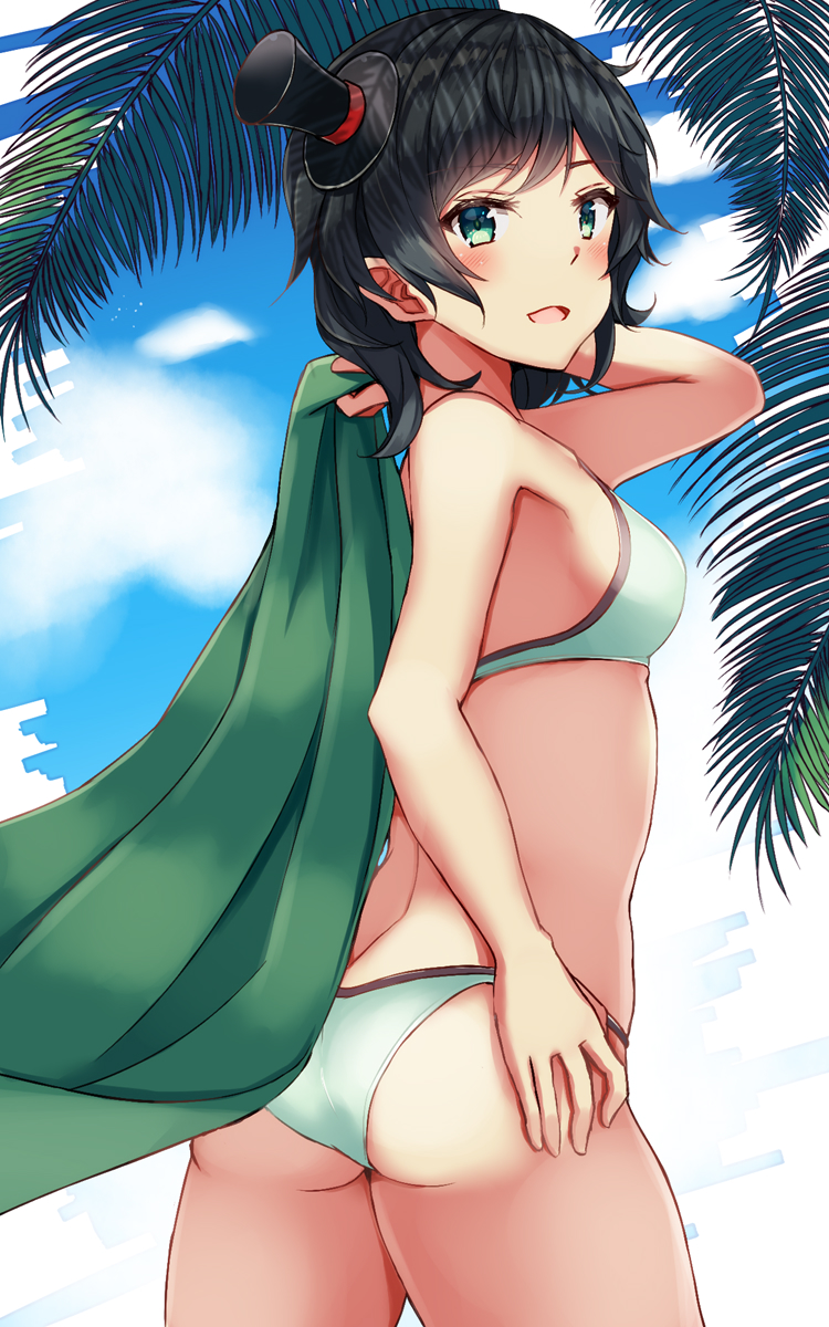 1girl ass bangs bikini black_hair blush breasts from_behind green_bikini green_eyes hat head_tilt highres holding kantai_collection matsukaze_(kantai_collection) medium_breasts mini_hat mini_top_hat natsu_narumi open_mouth palm_tree short_hair simple_background solo swimsuit top_hat towel tree wavy_hair