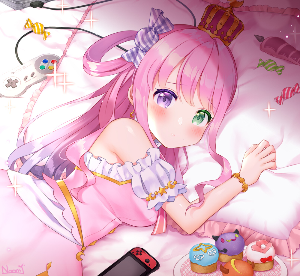 1girl bed blush breasts candy commentary_request controller crown cupcake dress earrings food game_controller heterochromia himemori_luna hololive jewelry long_hair looking_at_viewer lying naomi_(fantasia) nintendo_switch pillow pink_hair solo tray virtual_youtuber