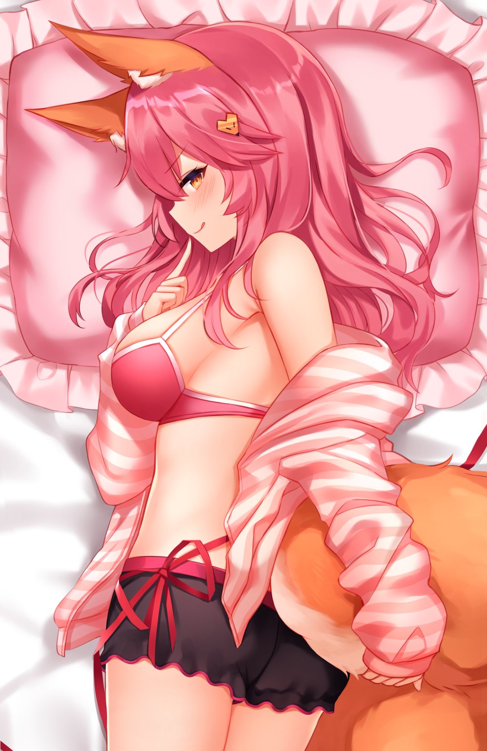 1girl animal_ear_fluff animal_ears bangs bare_shoulders black_shorts blush bra breasts closed_mouth fate/extra fate_(series) fox_ears fox_girl fox_tail hair_ornament highres index_finger_raised jacket large_breasts licking_lips long_hair long_sleeves looking_at_viewer looking_back lying off_shoulder on_stomach open_clothes open_jacket pillow pink_bra pink_hair pink_jacket short_shorts shorts shouu-kun smile solo striped_jacket tail tamamo_(fate)_(all) tamamo_no_mae_(fate) thighs tongue tongue_out underwear yellow_eyes