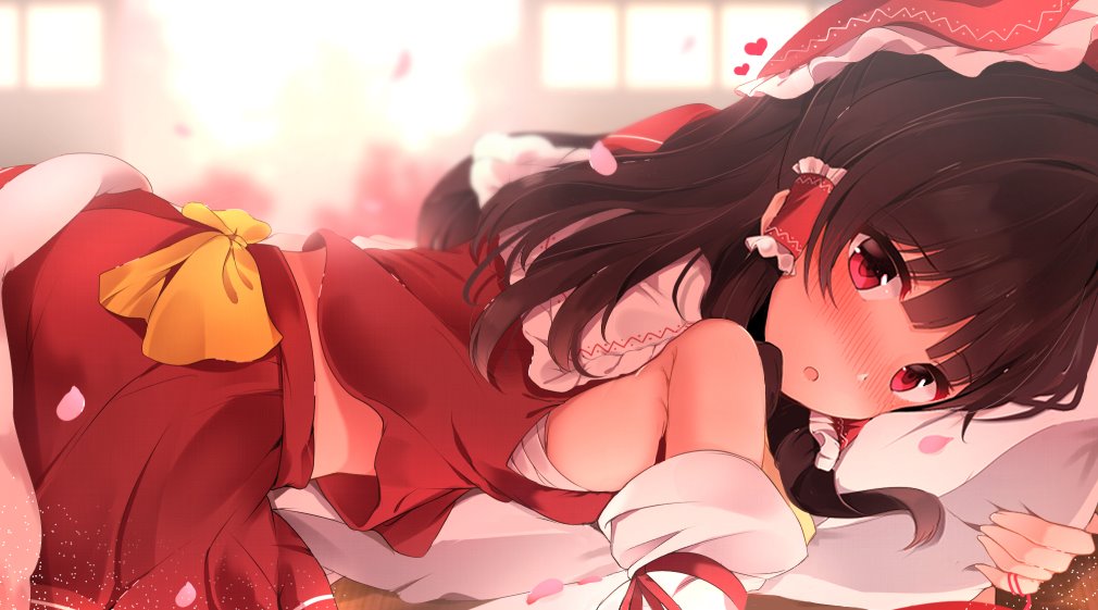 1girl bandages bangs bare_shoulders blurry blurry_background blush bow brown_hair commentary_request detached_sleeves eyebrows_visible_through_hair frilled_bow frills from_side hair_bow hair_tubes hakurei_reimu heart hunya long_hair long_sleeves looking_at_viewer lying nontraditional_miko nose_blush on_stomach open_mouth petals pillow pillow_hug red_bow red_eyes red_shirt red_skirt shirt skirt sleeveless sleeveless_shirt solo touhou yellow_bow