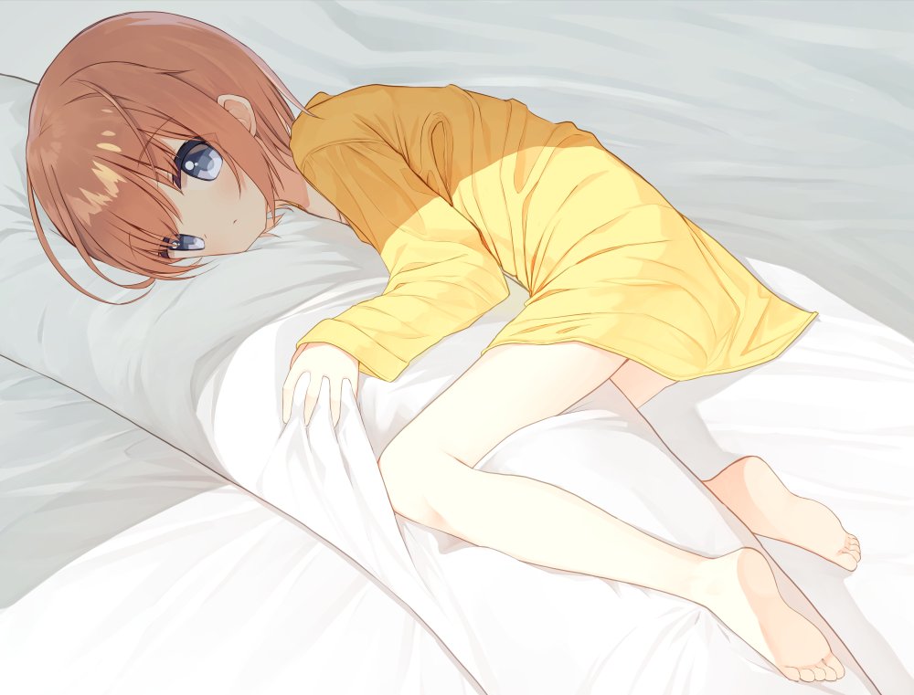 1girl bangs barefoot bed_sheet blush body_pillow brown_hair closed_mouth commentary_request eyebrows_visible_through_hair grey_hair long_sleeves lucena_winter lying object_hug on_side original pillow pillow_hug shirt sleeves_past_wrists soles solo yellow_shirt yuuhagi_(amaretto-no-natsu)