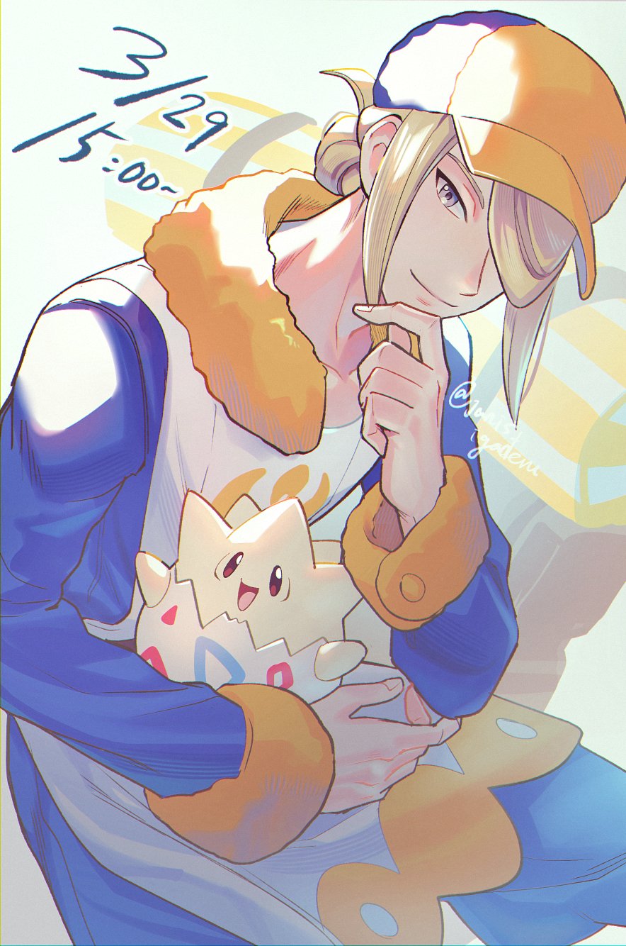 1boy blonde_hair blue_jumpsuit closed_mouth commentary grey_eyes hair_over_one_eye hand_on_own_chin hat highres holding holding_pokemon janis_(hainegom) jumpsuit long_sleeves looking_at_viewer male_focus pokemon pokemon_(creature) pokemon_legends:_arceus smile stroking_own_chin symbol-only_commentary togepi twitter_username volo_(pokemon) yellow_hat