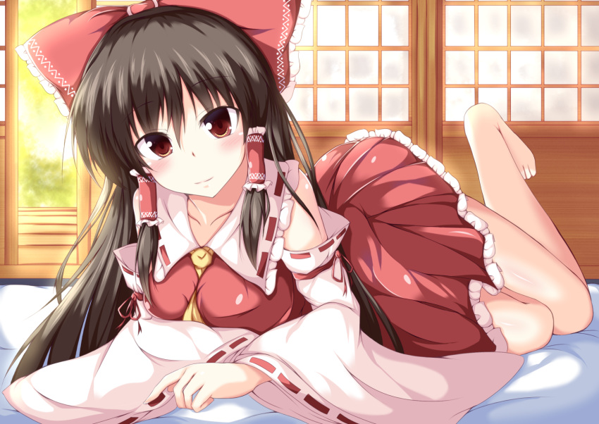 1girl ascot barefoot between_breasts black_hair blush bow breasts brown_eyes collarbone commentary_request detached_sleeves dress fookun futon hair_bow hair_tubes hakurei_reimu highres large_breasts leg_up long_hair long_sleeves looking_at_viewer lying on_stomach open_dress red_dress smile solo touhou wide_sleeves