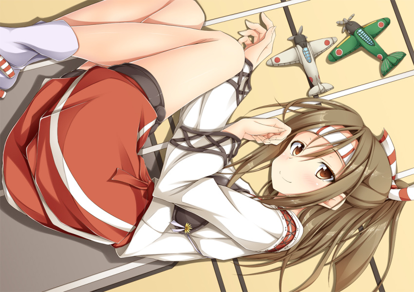 1girl blush brown_eyes brown_hair fetal_position hachimaki hair_ribbon headband high_ponytail japanese_clothes kantai_collection light_brown_hair long_hair looking_at_viewer lying muneate on_side personification ponytail ribbon shake_(ferit3) skirt smile solo zuihou_(kantai_collection)