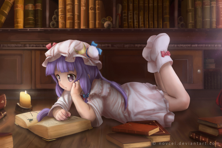 1girl book book_stack bookshelf boots bow candle capelet crescent dress full_body hair_bow hair_ornament hat highres legs_up long_hair long_sleeves lying mob_cap novcel on_stomach open_book patchouli_knowledge purple_hair reading solo touhou violet_eyes watermark web_address wide_sleeves