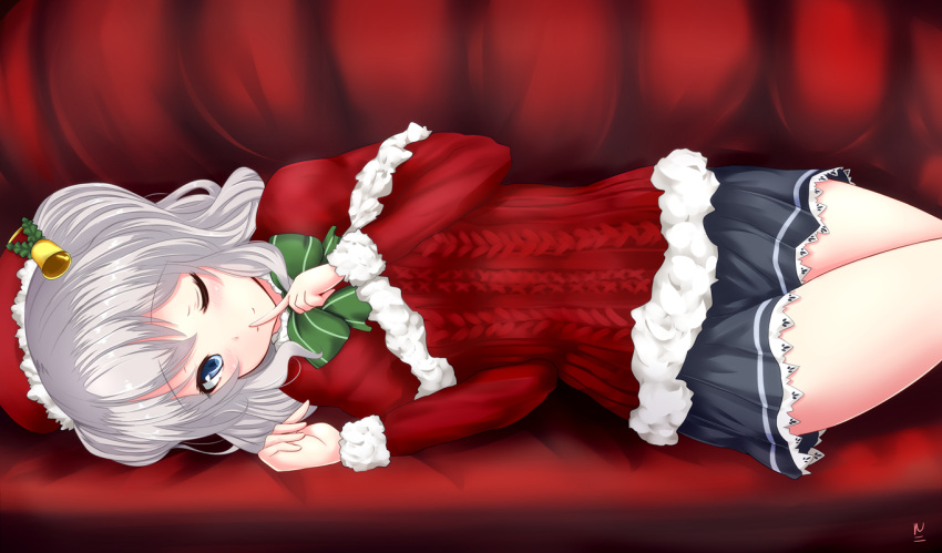 1girl bell blue_eyes capelet christmas couch finger_to_mouth fur_trim hair_bell hair_ornament hat kantai_collection kashima_(kantai_collection) looking_at_viewer lying myuu_(arisumeria) on_side one_eye_closed santa_hat short_hair short_twintails silver_hair skirt solo sweater twintails