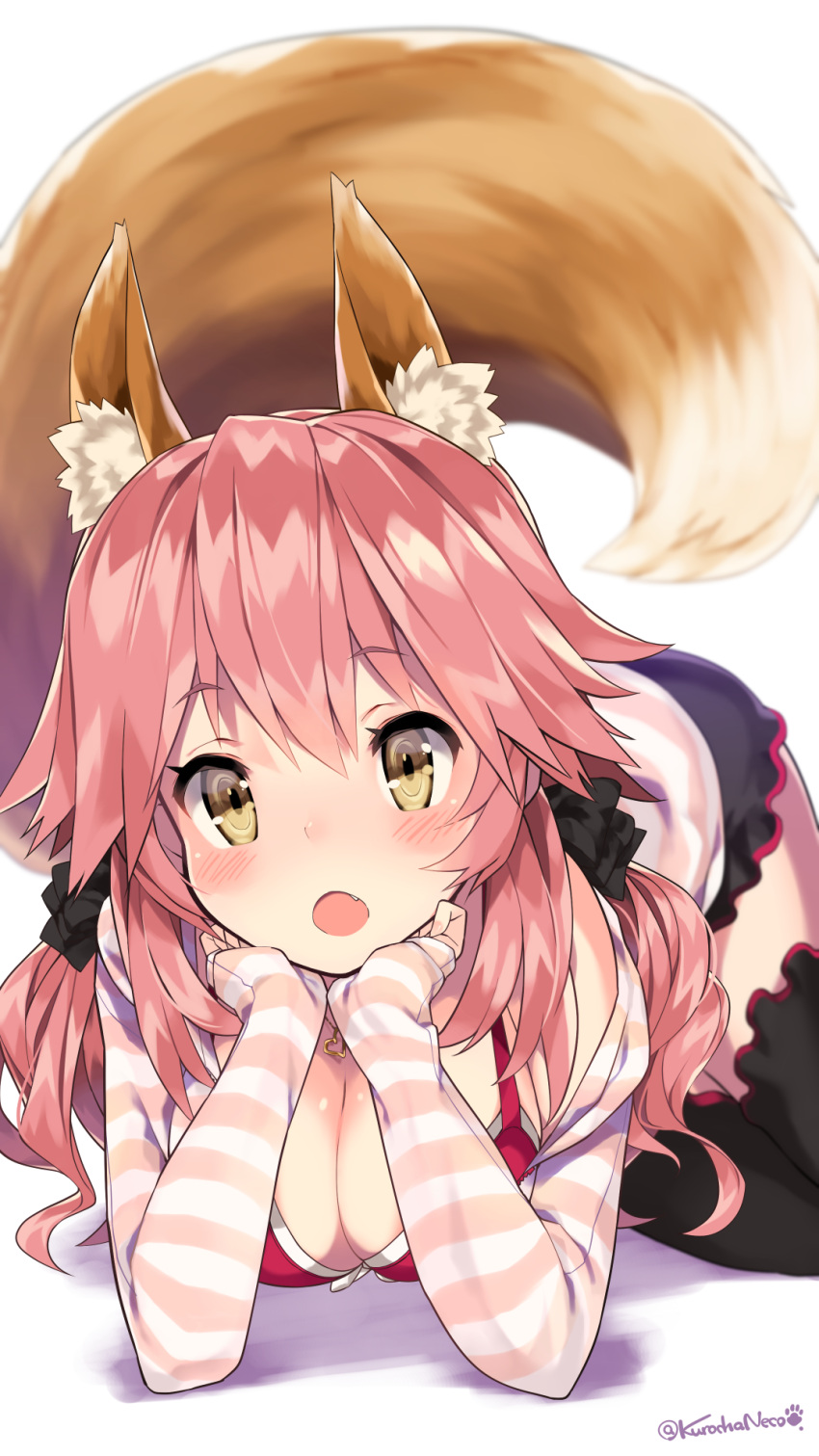 1girl animal_ears black_legwear blurry blush breasts caster_(fate/extra) casual chin_rest cleavage depth_of_field fang fate/extra fate_(series) fox_ears fox_tail highres jewelry kuro_chairo_no_neko light_brown_eyes looking_at_viewer low_twintails lying necklace on_stomach open_mouth pink_hair scrunchie sleeves_past_wrists solo tail thigh-highs twintails twitter_username