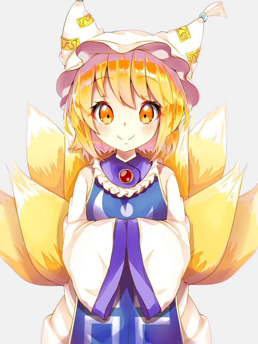 1girl bangs blonde_hair blush commentary_request cowboy_shot dress fox_tail grey_background hands_together hat highres long_sleeves looking_at_viewer multiple_tails pillow_hat shiny shiny_hair short_hair simple_background smile solanikieru solo tabard tail touhou white_dress wide_sleeves yakumo_ran younger