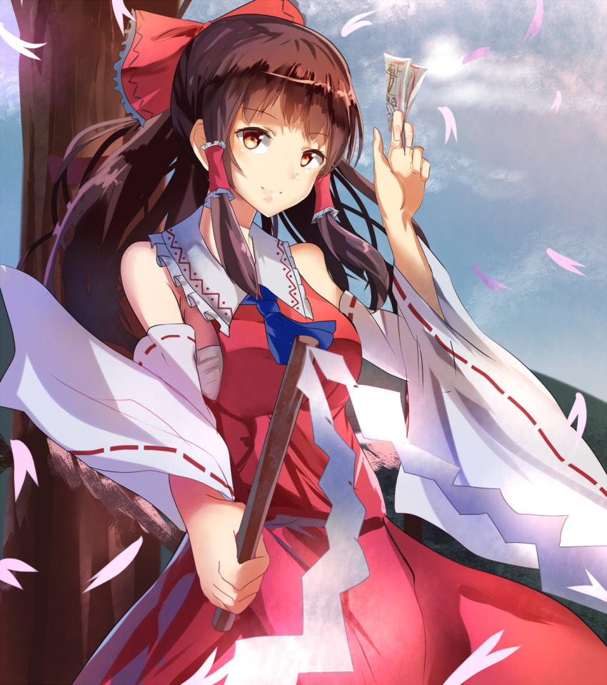 1girl ascot bare_shoulders bow brown_eyes brown_hair clouds cloudy_sky detached_sleeves dress gohei hair_bow hair_tubes hakurei_reimu highres hizagawa_rau long_hair long_sleeves looking_at_viewer petals red_bow red_dress sarashi sky smile solo spell_card touhou tree wide_sleeves