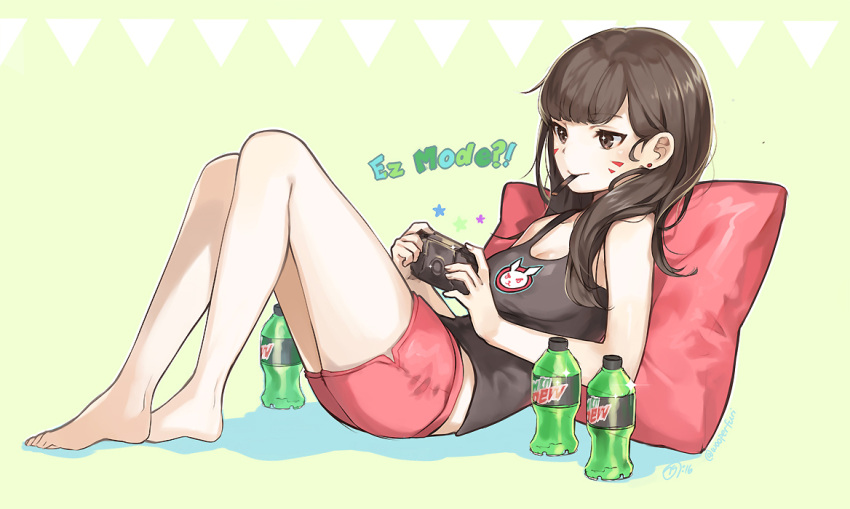 1girl bare_arms bare_legs bare_shoulders barefoot black_shirt blush bottle brown_eyes brown_hair closed_mouth collarbone controller d.va_(overwatch) earrings facepaint facial_mark full_body glint green_background handheld_game_console holding jewelry knees_up long_hair lying mouth_hold mouthsmile naguri on_back overwatch pillow pink_shorts playing_games playstation_vita shirt shorts simple_background sleeveless smile solo stud_earrings tank_top text whisker_markings
