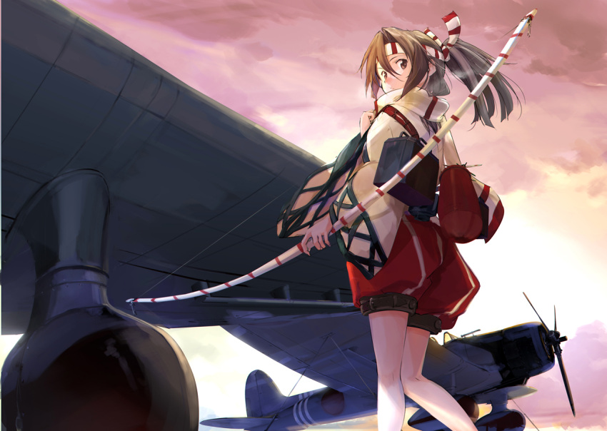 1girl aichi_d3a aircraft airplane bow_(weapon) brown_eyes brown_hair from_below frown headband high_ponytail long_sleeves looking_back solo sunrise takeshima_satoshi weapon wide_sleeves zuihou_(kantai_collection)