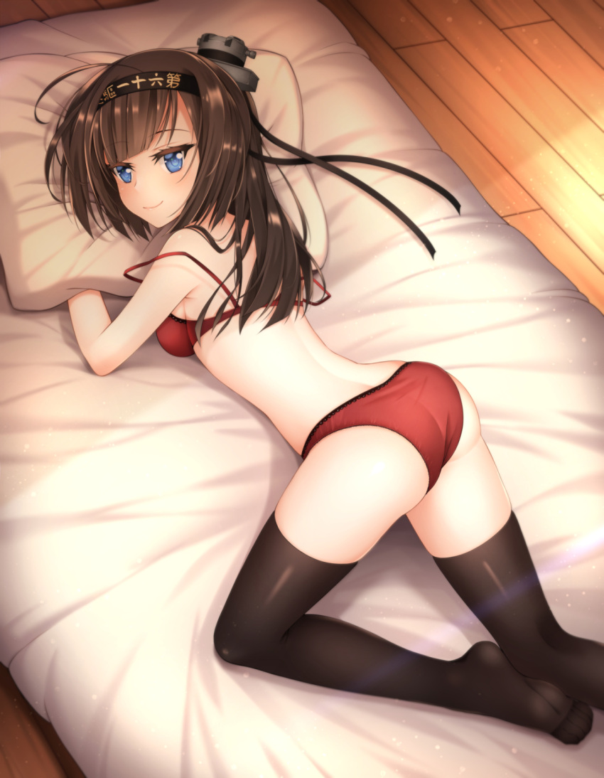 1girl ahoge akizuki_(kantai_collection) ass black_legwear blue_eyes bra breasts brown_hair clothes_writing hachimaki headband healther highres kantai_collection long_hair looking_at_viewer looking_back lying off_shoulder on_stomach panties pillow ponytail red_bra red_panties smile solo strap_slip thigh-highs underwear