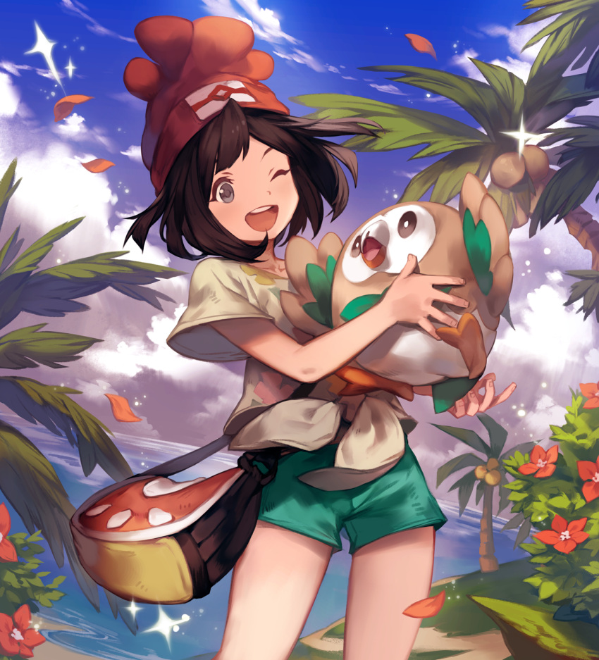1girl ;d aqua_shorts bag bangs beach beanie black_hair blue_sky bush clouds cloudy_sky coconut coconut_tree collarbone cowboy_shot day eyelashes female_protagonist_(pokemon_sm) flat_chest floral_print front-tie_top grey_eyes happy hat highres holding horizon lee_hyeseung legs_apart light_particles ocean one_eye_closed open_mouth outdoors palm_tree paw_print petals pokemon pokemon_(creature) pokemon_(game) pokemon_sm print_shirt red_flower red_hat rowlet shirt short_hair short_shorts short_sleeves shorts shoulder_bag sky smile sparkle spread_fingers standing swept_bangs teeth tied_shirt tree