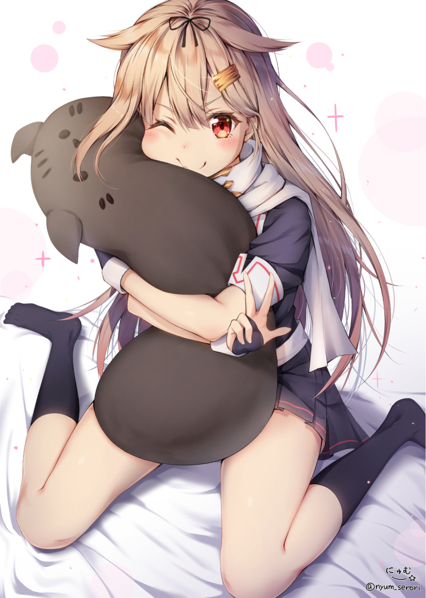 1girl black_legwear black_serafuku black_skirt blonde_hair blush closed_mouth fingerless_gloves gloves hair_flaps hair_ornament hairclip highres kantai_collection long_hair looking_at_viewer nyum object_hug on_bed one_eye_closed pleated_skirt red_eyes remodel_(kantai_collection) scarf school_uniform serafuku sitting skirt smile socks solo straight_hair stuffed_toy twitter_username v wariza yuudachi_(kantai_collection)