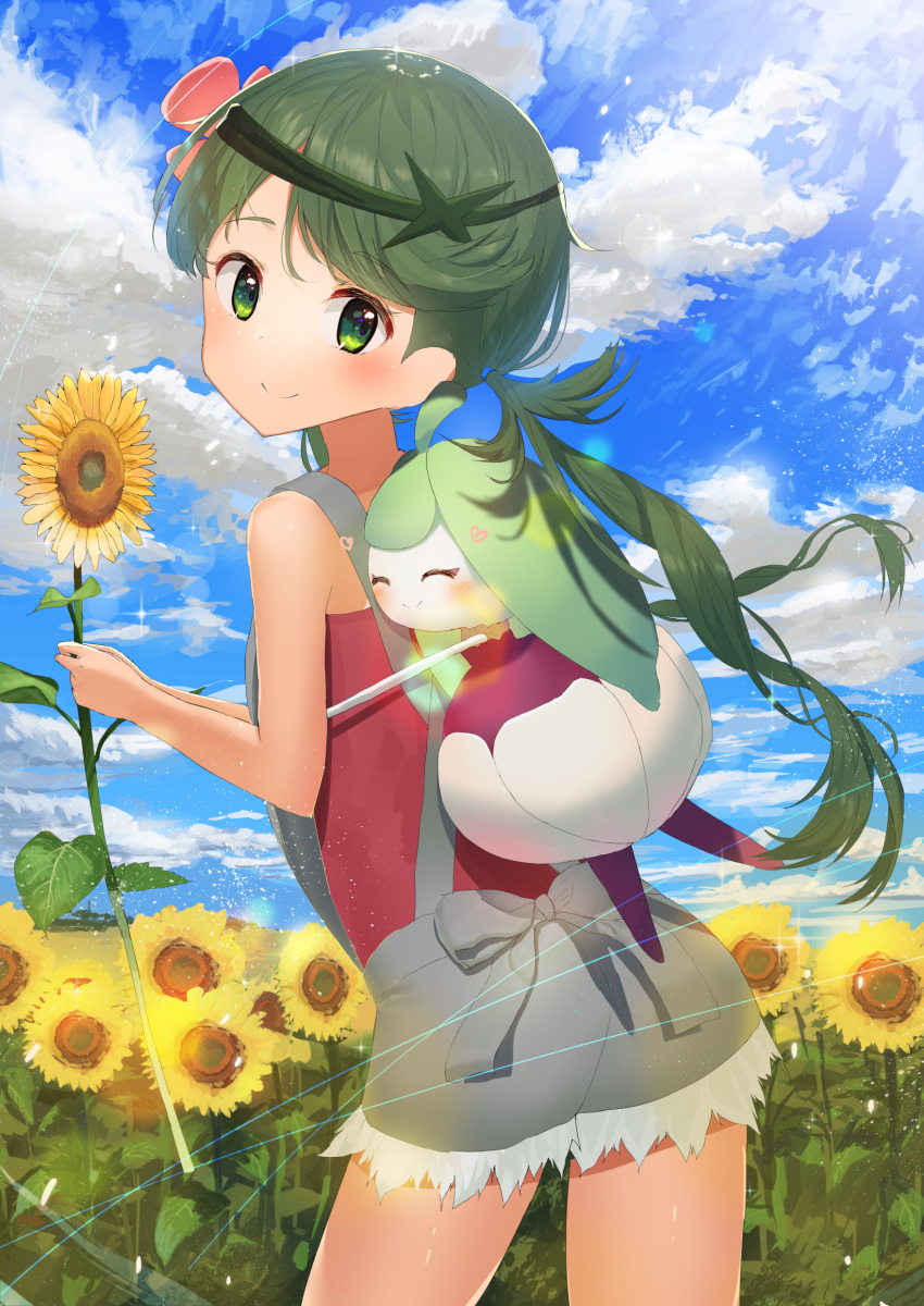 1girl absurdres akamizuki_(akmzk) blush cowboy_shot field flower green_eyes green_hair hair_flower hair_ornament highres holding holding_flower long_hair looking_at_viewer looking_back mallow_(pokemon) outdoors overalls pokemon pokemon_(game) pokemon_sm sky smile solo steenee sunflower trial_captain twintails