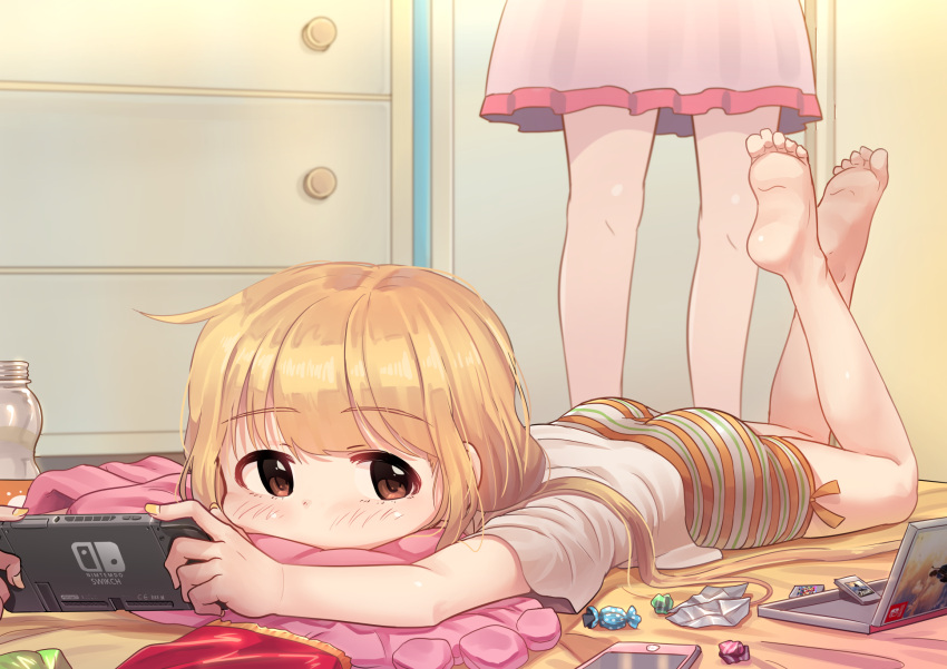 2girls ass barefoot blonde_hair blush candy cellphone eyebrows_visible_through_hair feet food futaba_anzu highres idolmaster idolmaster_cinderella_girls kamille_(vcx68) long_hair looking_at_viewer lying nail_polish nintendo nintendo_switch on_stomach phone red_eyes smartphone soles toes twintails yellow_nails