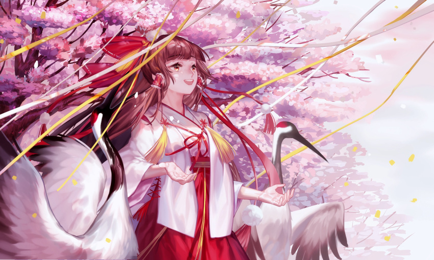 1girl :d alternate_costume bangs bird blunt_bangs bow brown_hair cherry_blossoms confetti cowboy_shot crane cross-laced_clothes eyebrows_visible_through_hair hair_bow hair_tubes hakama hakurei_reimu happy highres japanese_clothes kimono long_hair long_sleeves looking_away open_mouth outdoors pom_pom_(clothes) red-crowned_crane red_bow red_eyes red_hakama round_teeth smile solo spring_(season) standing tassel teeth touhou tree wei_li wide_sleeves