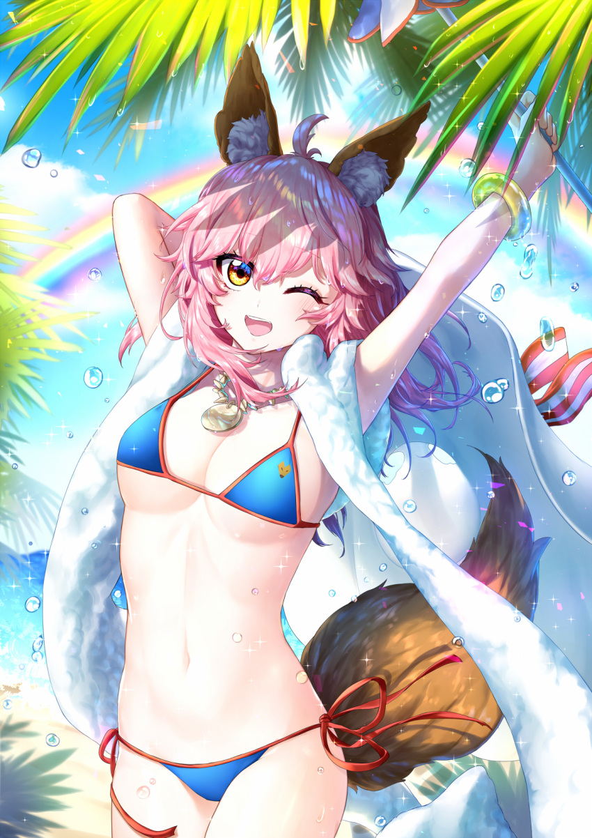 1girl ;d ahoge arms_up bangle bangs beach_towel bikini blue_bikini blue_sky blush bracelet breasts brown_eyes cleavage collarbone cowboy_shot day eyebrows_visible_through_hair fate/grand_order fate_(series) food fox_tail highres hm_(wonhml) holding jewelry large_breasts long_hair navel necklace one_eye_closed open_mouth outdoors palm_tree pendant pink_hair rainbow red_ribbon ribbon side-tie_bikini sky smile solo sparkle standing stomach strap_gap string_bikini swimsuit tail tamamo_(fate)_(all) tamamo_no_mae_(swimsuit_lancer)_(fate) towel towel_around_neck tree water_drop