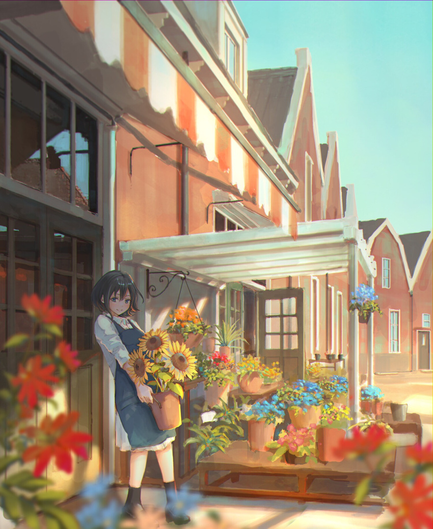 1girl apron awning bangs black_footwear black_hair black_legwear blue_apron blue_eyes blurry_foreground building collared_dress door dress florist flower hanging_plant highres holding long_sleeves looking_at_viewer open_door original outdoors pallet plant potted_plant sho_(shoichi-kokubun) shoes short_hair smile socks solo standing sunflower white_dress window