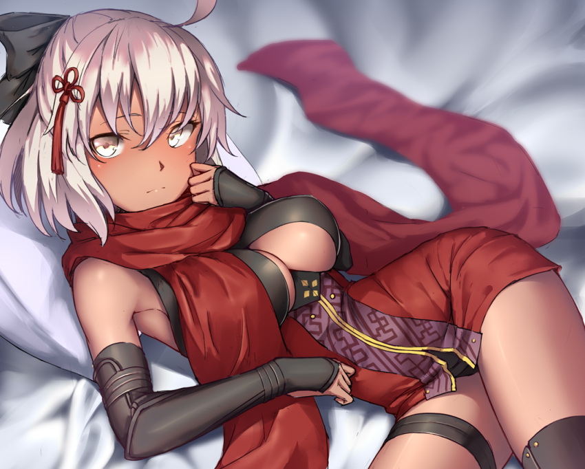 1girl ahoge arm_guards bangs bed_sheet black_bow black_legwear blurry blurry_background blush bow breasts cleavage closed_mouth commentary_request dark_skin depth_of_field dress eyebrows_visible_through_hair fate/grand_order fate_(series) hair_between_eyes hair_bow hair_ornament hand_up koha-ace large_breasts looking_at_viewer lying okita_souji_(alter)_(fate) okita_souji_(fate)_(all) pillow red_dress red_scarf ryuinu scarf silver_hair solo tassel thigh-highs yellow_eyes