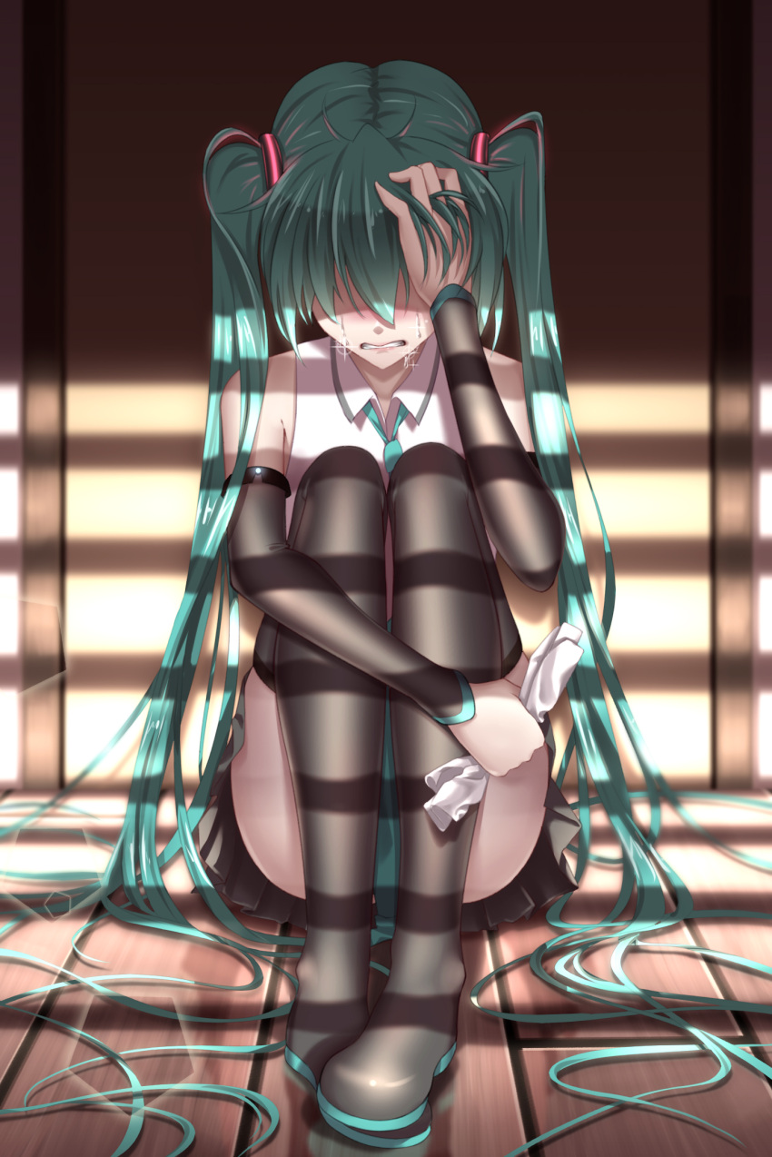 1girl aqua_hair black_footwear black_skirt boots clenched_teeth crying detached_sleeves full_body geduan hair_ornament hair_over_one_eye hatsune_miku highres holding long_hair miniskirt pleated_skirt shirt sitting skirt sleeveless sleeveless_shirt solo tears teeth thigh-highs thigh_boots twintails very_long_hair vocaloid white_shirt wooden_floor