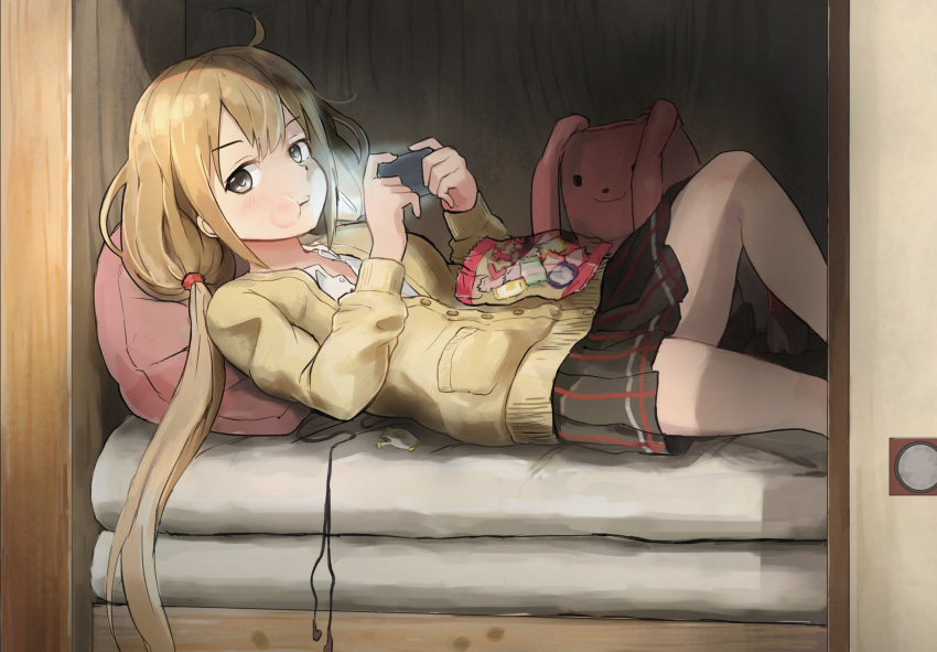 1girl ahoge black_eyes black_skirt buttons candy candy_wrapper chewing commentary_request earphones earphones earphones_removed food futaba_anzu handheld_game_console highres holding idolmaster idolmaster_cinderella_girls kamemaru light long_hair long_sleeves looking_at_viewer low_twintails lying on_back on_bed pillow playstation_portable pleated_skirt skirt solo stuffed_animal stuffed_bunny stuffed_toy sweater twintails wrapper