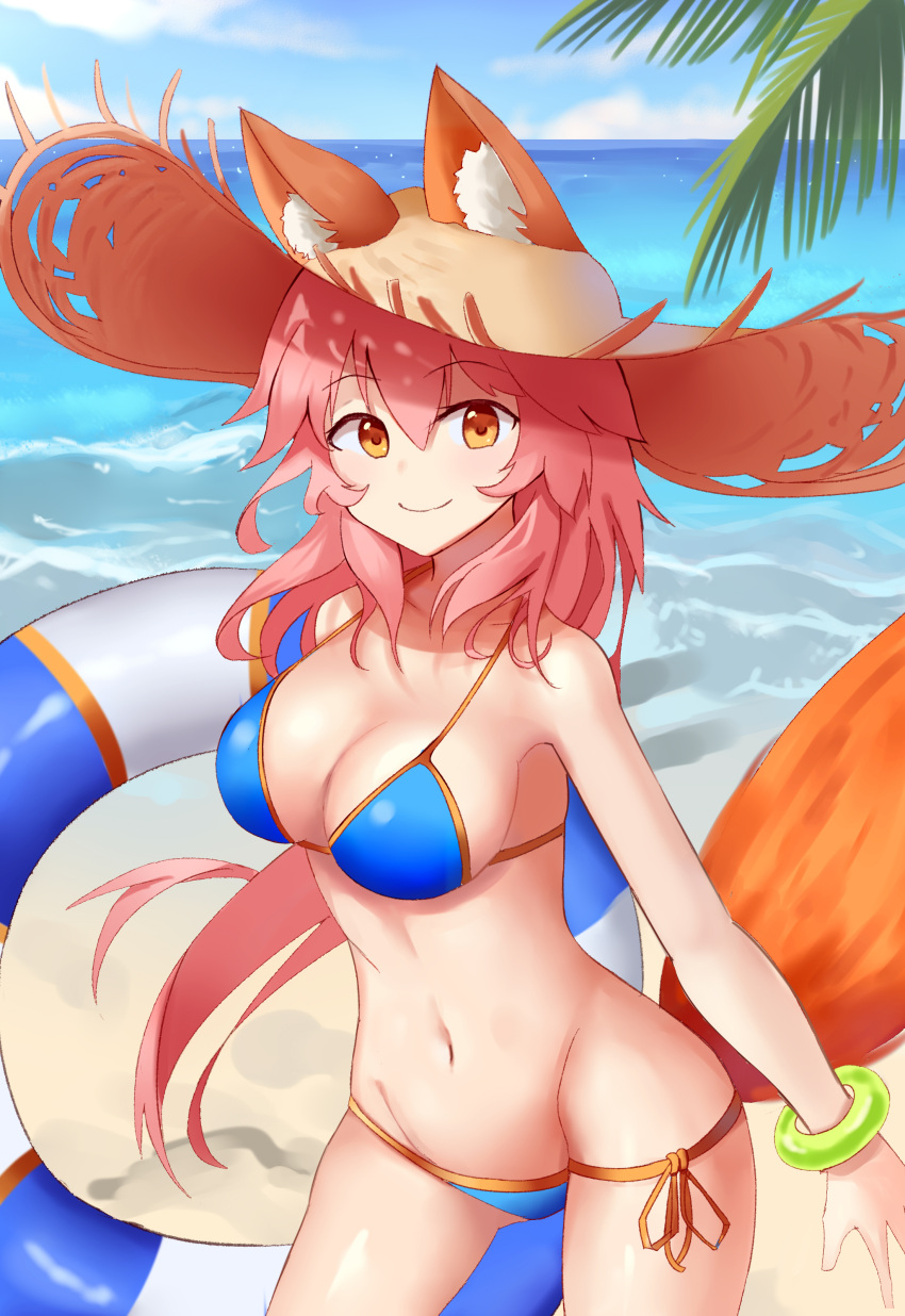 1girl absurdres animal_ears april_cho bikini blue_bikini breasts cleavage day ears_through_headwear fate/extella fate/extra fate/grand_order fate_(series) fox_ears fox_tail groin hat highres innertube large_breasts long_hair looking_at_viewer navel ocean outdoors palm_tree pink_hair side-tie_bikini smile solo straw_hat swimsuit tail tamamo_(fate)_(all) tamamo_no_mae_(swimsuit_lancer)_(fate) tree yellow_eyes