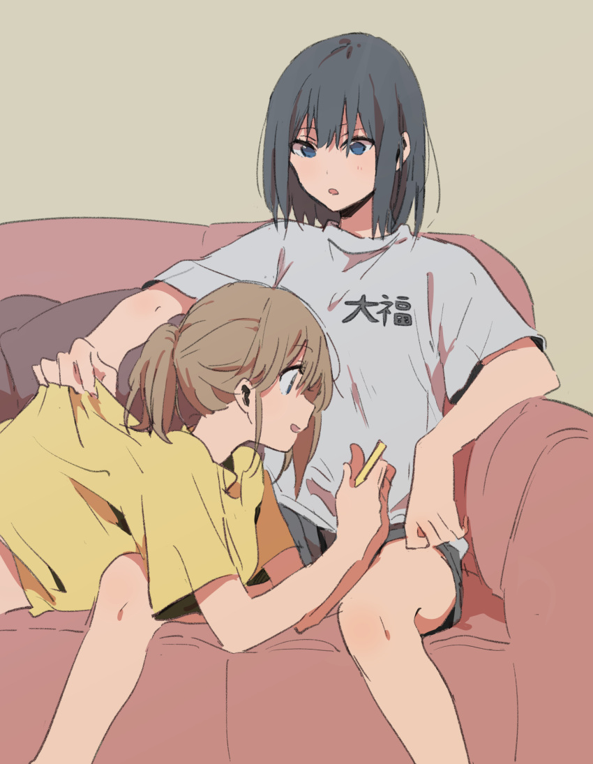 2girls :d :o black_hair black_shorts brown_hair clothes_pull clothes_writing couch cushion grey_background grey_shirt highres holding lying monsieur multiple_girls on_back open_mouth original parted_lips ponytail shirt short_hair short_shorts short_sleeves shorts simple_background sitting smile spread_legs t-shirt yellow_shirt