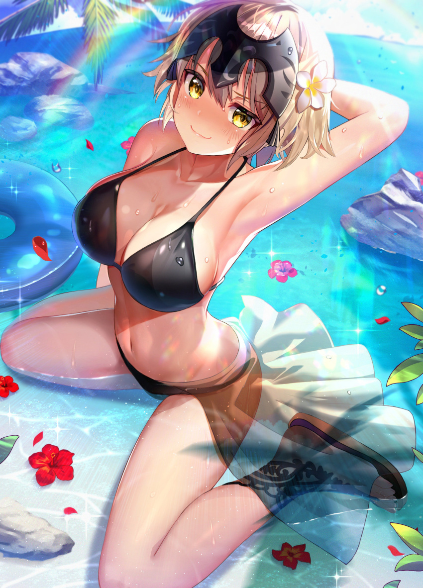 1girl absurdres arched_back arm_behind_head arm_up armpits bangs bare_arms bare_legs bare_shoulders bikini black_bikini blonde_hair blue_sky blush breasts cleavage closed_mouth clouds collarbone commentary_request day eyebrows_visible_through_hair fate/grand_order fate_(series) flower from_above full_body hair_between_eyes hair_flower hair_ornament headpiece hibiscus highres horizon innertube jeanne_d'arc_(alter)_(fate) jeanne_d'arc_(fate)_(all) large_breasts looking_at_viewer navel nayuta_(una) ocean outdoors palm_tree petals petals_on_liquid rainbow red_flower rock sandals sarong see-through shadow shiny shiny_skin short_hair sidelocks sitting skirt sky smile smug solo sparkle stomach sunlight swimsuit tree wariza water_drop wet white_flower white_skirt yellow_eyes