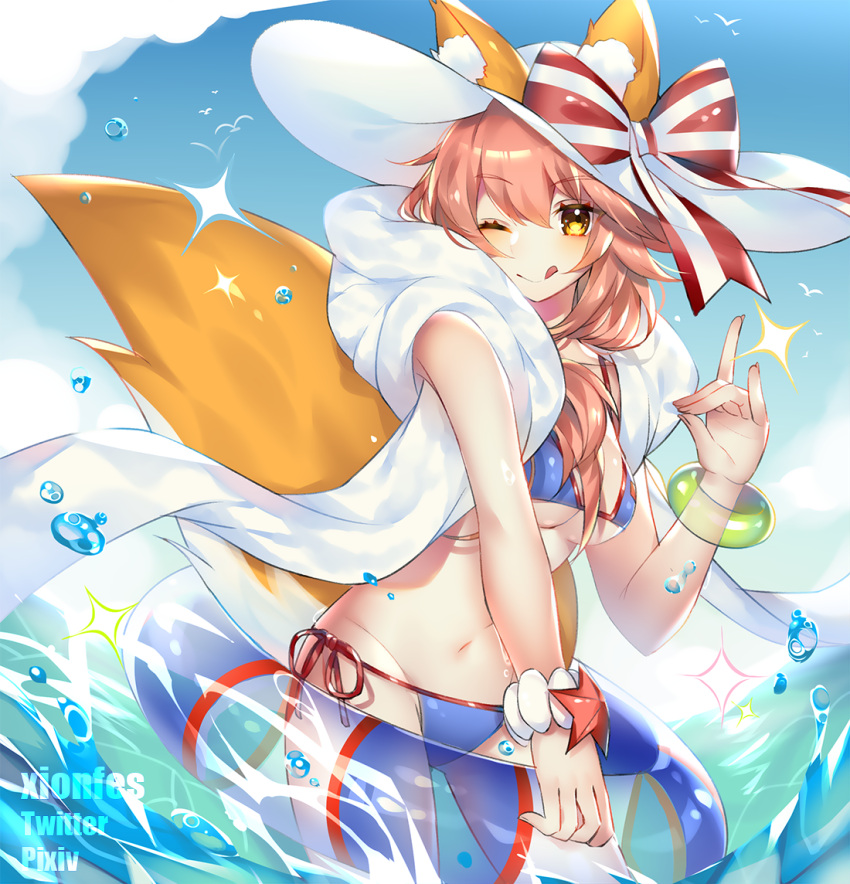 1girl animal_ear_fluff animal_ears bikini blue_bikini blush breasts cleavage ears_through_headwear fate/grand_order fate_(series) fox_ears fox_shadow_puppet fox_tail groin hat innertube large_breasts looking_at_viewer navel ocean one_eye_closed pink_hair side-tie_bikini solo sun_hat swimsuit tail tamamo_(fate)_(all) tamamo_no_mae_(swimsuit_lancer)_(fate) tongue type-moon water xionfes yellow_eyes