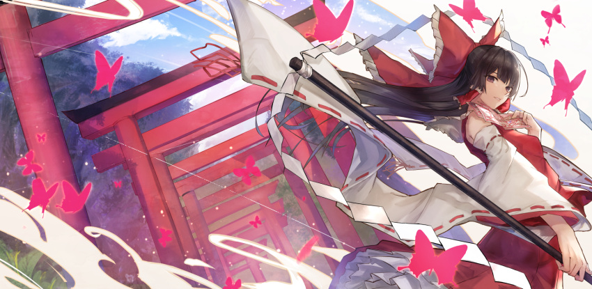 1girl black_hair bow brown_eyes bug butterfly cowboy_shot day detached_sleeves dutch_angle eisuto floating_hair frilled_bow frills hair_bow hair_tubes hakurei_reimu highres holding holding_staff insect long_hair looking_at_viewer outdoors parted_lips red_bow red_shirt ribbon-trimmed_sleeves ribbon_trim shirt sleeveless sleeveless_shirt smile solo staff standing torii touhou very_long_hair