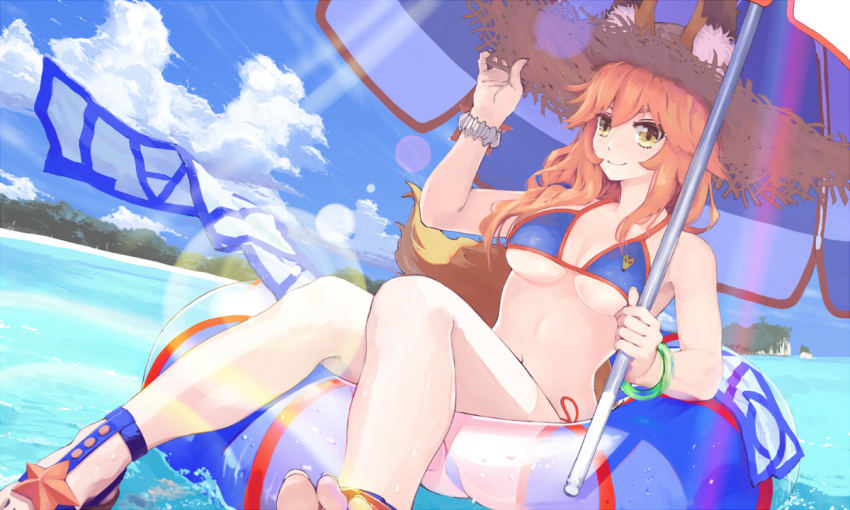 1girl animal_ear_fluff animal_ears beach_umbrella bikini blue_bikini breasts cleavage collarbone day ears_through_headwear fate/extra fate/grand_order fate_(series) fox_ears fox_tail hat innertube large_breasts navel ocean outdoors parasol pink_hair satsuki_(satsuki1987) side-tie_bikini solo straw_hat swimsuit tail tamamo_(fate)_(all) tamamo_no_mae_(swimsuit_lancer)_(fate) towel umbrella yellow_eyes