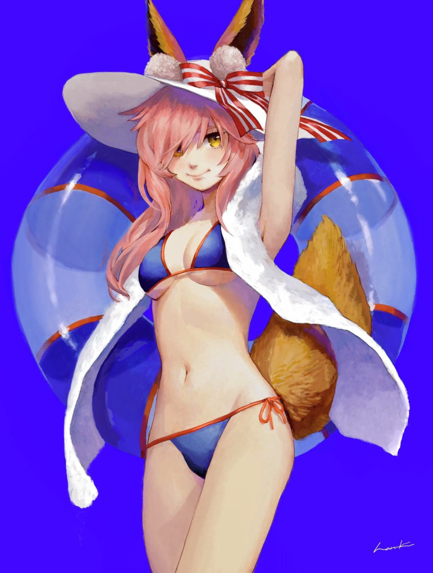1girl animal_ear_fluff animal_ears arms_behind_head arms_up bikini blue_background blue_bikini breasts cleavage ears_through_headwear fate/grand_order fate_(series) fox_ears fox_tail groin hat highres innertube long_hair looking_at_viewer medium_breasts navel pink_hair side-tie_bikini simple_background smile solo standing straw_hat swimsuit tail tamamo_(fate)_(all) tamamo_no_mae_(swimsuit_lancer)_(fate) yellow_eyes yosay_0