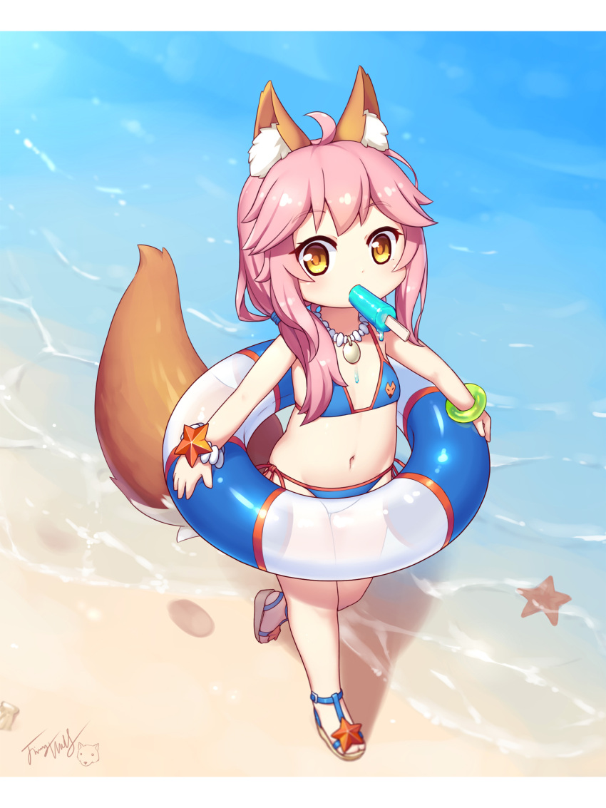 1girl animal_ear_fluff animal_ears bangs bare_shoulders beach bikini blue_bikini blush bracelet brown_footwear brown_hair commentary_request cute day eyebrows_visible_through_hair fate/extra fate/grand_order fate_(series) flat_chest food food_in_mouth fox_ears fox_girl fox_tail highres holding holding_innertube innertube jewelry langbazi letterboxed long_hair looking_at_viewer mouth_hold navel necklace outdoors pink_hair popsicle sand sandals side-tie_bikini sidelocks signature solo standing standing_on_one_leg starfish swimsuit tail tail_raised tamamo_(fate)_(all) tamamo_no_mae_(swimsuit_lancer)_(fate) water younger