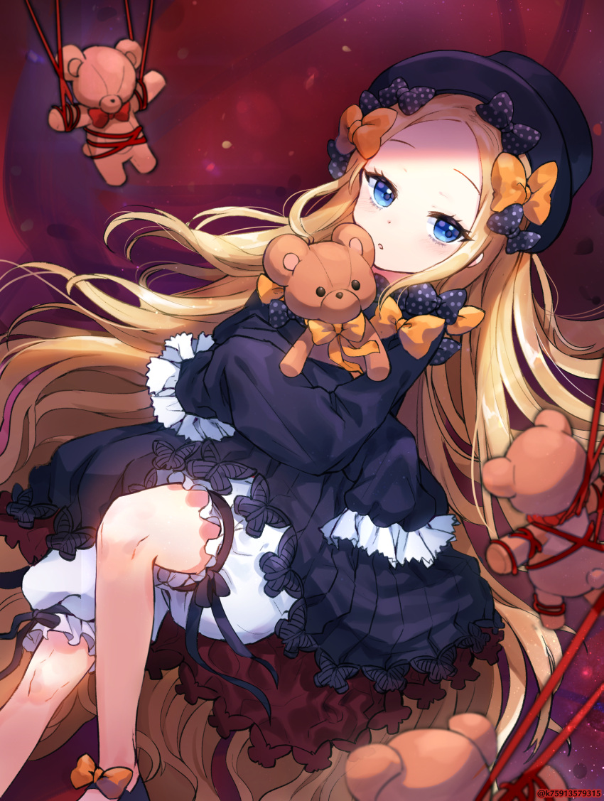 1girl abigail_williams_(fate/grand_order) bangs black_dress black_hat blonde_hair blue_eyes blush bound bow commentary_request dress fate/grand_order fate_(series) forehead frilled_sleeves frills hair_bow hat highres lerome long_hair object_hug orange_bow parted_bangs polka_dot polka_dot_bow red_bow red_ribbon ribbon ribbon_bondage sleeves_past_fingers sleeves_past_wrists solo stuffed_animal stuffed_toy teddy_bear tied_up underwear very_long_hair white_bloomers