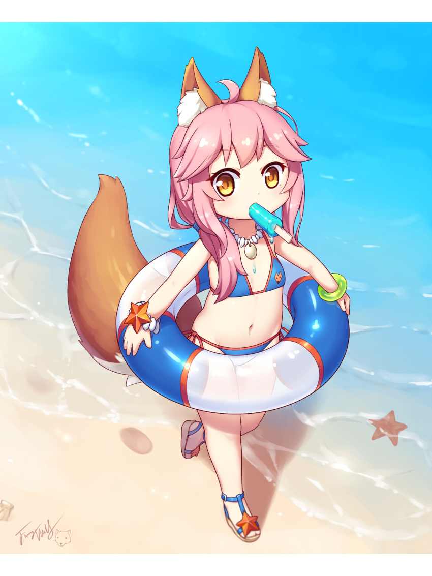 1girl animal_ear_fluff animal_ears bangs bare_shoulders beach bikini blue_bikini blush bracelet brown_footwear brown_hair commentary_request day eyebrows_visible_through_hair fate/grand_order fate_(series) flat_chest food food_in_mouth fox_ears fox_girl fox_tail highres holding holding_innertube innertube jewelry langbazi letterboxed long_hair looking_at_viewer mouth_hold navel necklace outdoors pink_hair popsicle revision sand sandals side-tie_bikini sidelocks signature solo standing standing_on_one_leg starfish swimsuit tail tail_raised tamamo_(fate)_(all) tamamo_no_mae_(swimsuit_lancer)_(fate) water younger