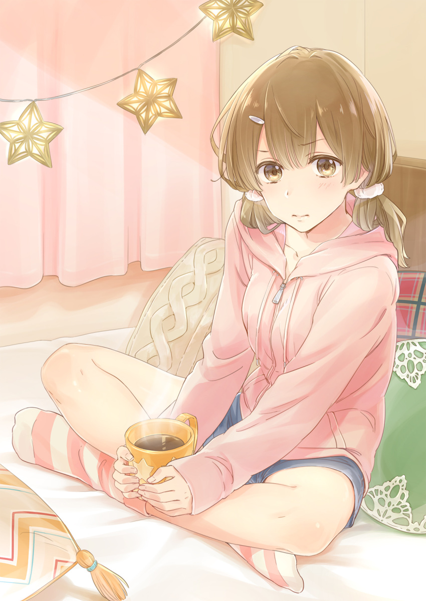 1girl blush brown_hair cup curtains drink full_body hair_ornament hairclip highres hood hoodie indoors kapi_(kapi_219) legs_crossed looking_at_viewer loose_socks mug on_bed original pillow pink_hoodie short_shorts shorts sitting socks striped striped_legwear twintails