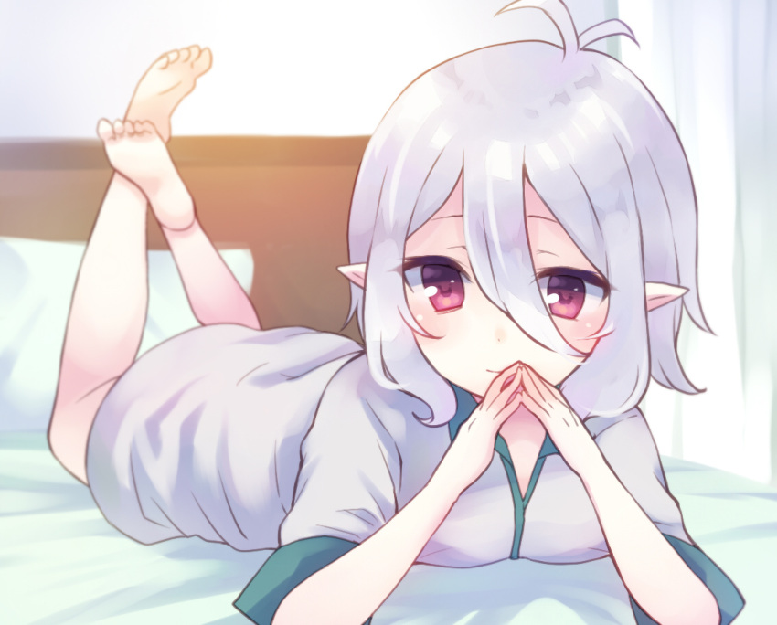 1girl bangs barefoot bed blush closed_mouth commentary_request dress eyebrows_behind_hair grey_dress gucchiann hair_between_eyes hands_up indoors kokkoro_(princess_connect!) legs_up looking_at_viewer lying on_bed on_stomach pillow pointy_ears princess_connect! princess_connect!_re:dive red_eyes short_sleeves silver_hair smile soles solo