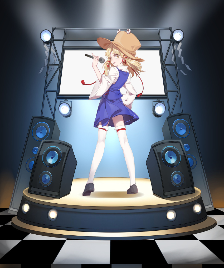 1girl absurdres aibivy black_footwear blonde_hair blue_skirt blue_vest brown_hat checkered checkered_floor from_behind hair_ribbon hand_on_hip hat highres holding holding_microphone legs_apart long_hair looking_at_viewer looking_back microphone miniskirt moriya_suwako red_ribbon ribbon shide shirt shoes skirt skirt_set smile solo speaker stage standing thigh-highs touhou tress_ribbon vest white_legwear white_shirt wide_sleeves yellow_eyes