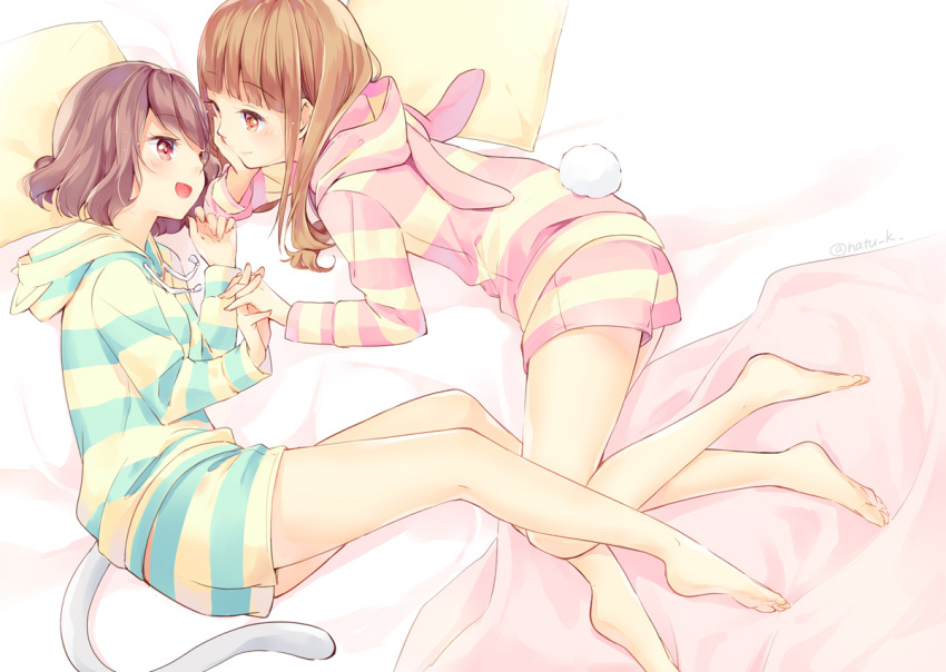 2girls :d animal_hood bangs barefoot bed_sheet blanket blunt_bangs brown_eyes brown_hair bunny_hood bunny_tail cat_hood cat_tail chin_rest commentary_request drawstring hand_holding hazuki_natsu hood hood_down interlocked_fingers long_hair long_sleeves looking_at_another lying multiple_girls on_side open_mouth original pajamas pillow red_eyes short_hair shorts smile striped striped_hoodie striped_shorts tail twitter_username yuri