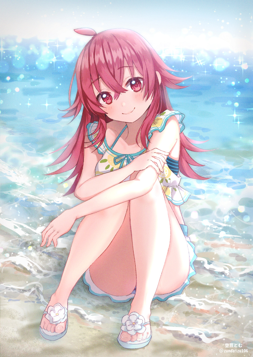 1girl ahoge artist_name bangs beach bikini bikini_skirt closed_mouth commentary day eyebrows_visible_through_hair frilled_bikini frills hand_on_own_arm head_tilt highres idolmaster idolmaster_shiny_colors komiya_kaho leg_hug long_hair looking_at_viewer ocean outdoors red_eyes redhead sandals sitting smile solo soramame_tomu sparkle swimsuit twitter_username waves white_bikini white_footwear