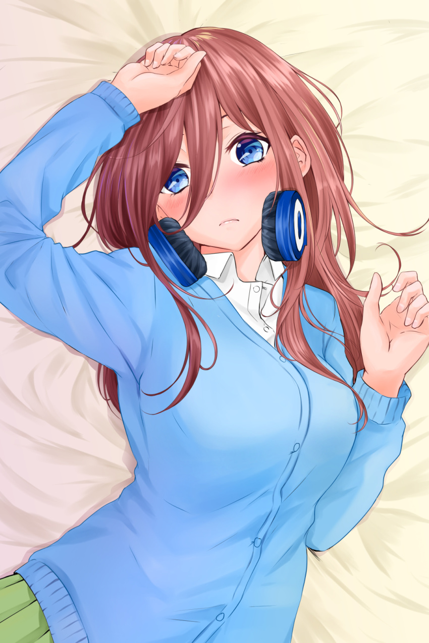 1girl blue_cardigan blue_eyes blush breasts brown_hair collared_shirt go-toubun_no_hanayome green_skirt hair_between_eyes headphones headphones_around_neck highres large_breasts long_hair looking_at_viewer lying nakano_miku on_back on_bed pleated_skirt shirt skirt solo umino_haruka_(harukaumino6) upper_body white_shirt