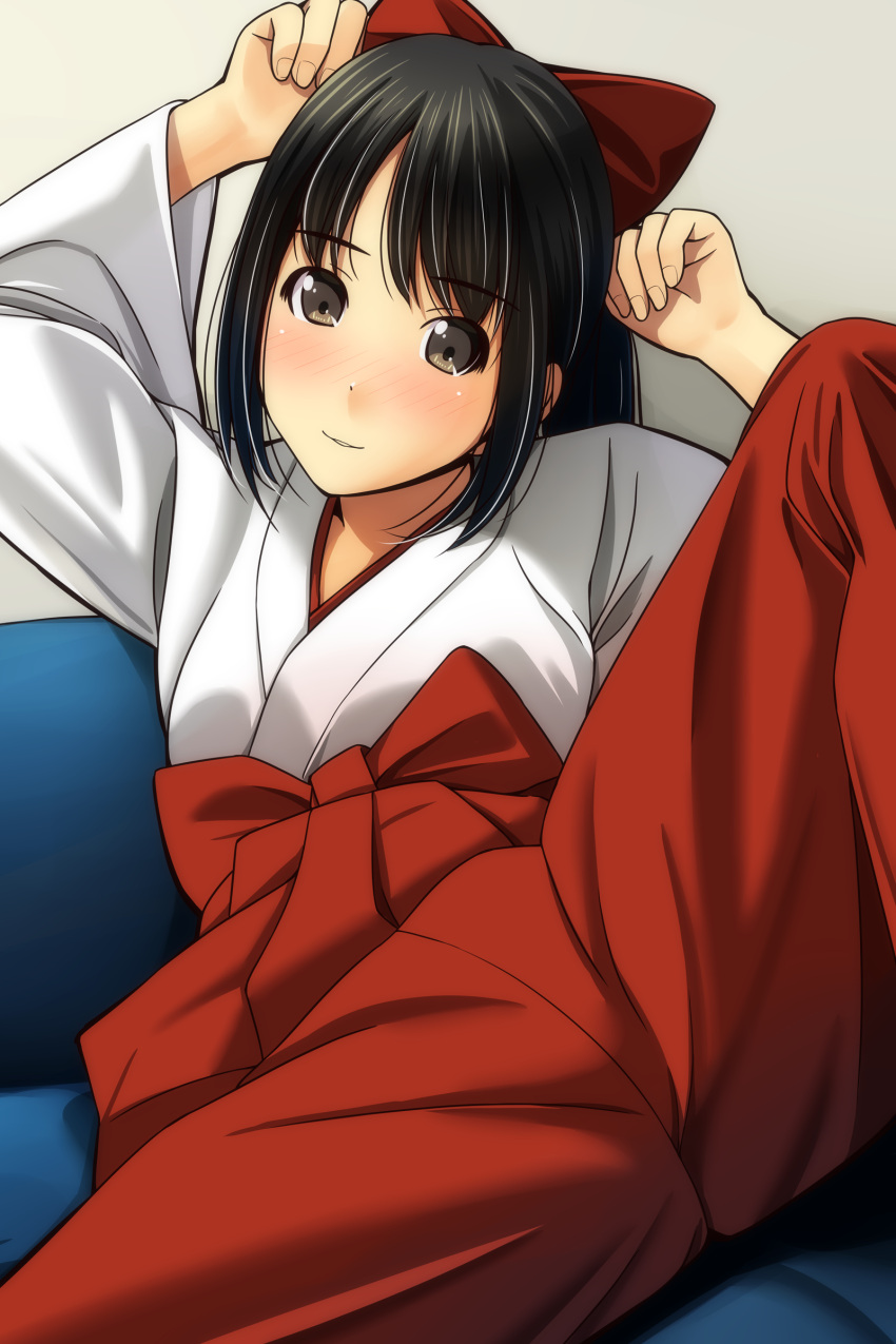 1girl absurdres arms_up bangs black_hair blush bow brown_eyes couch eyebrows_visible_through_hair fingernails hair_bow hakama_pants head_tilt highres japanese_clothes kimono light_smile long_hair long_sleeves looking_at_viewer matsunaga_kouyou miko nose_blush on_couch original pants parted_lips red_bow red_pants sidelocks smile solo spread_legs white_kimono wide_sleeves